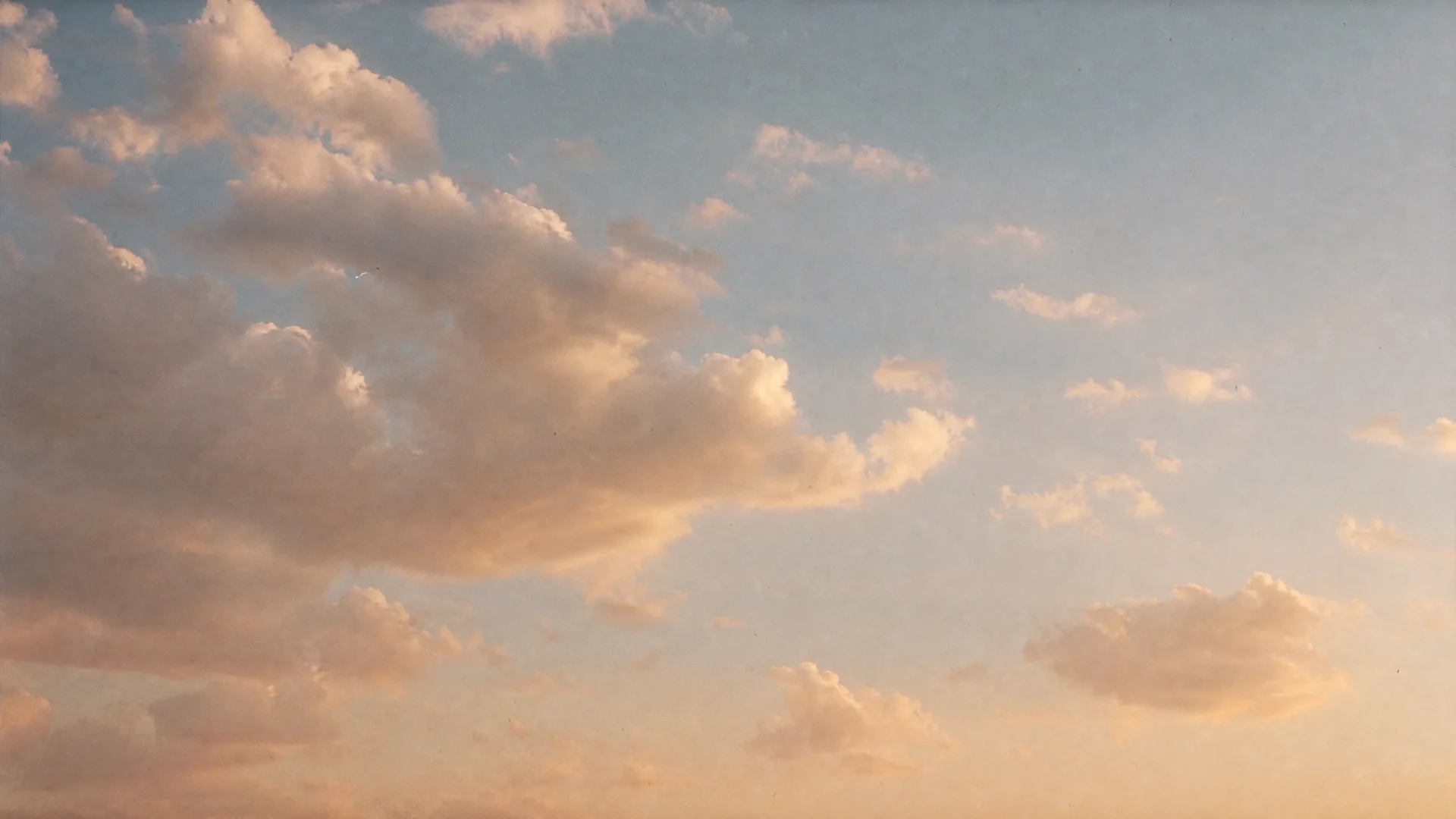 Soft clouds drifting in a pale golden sky